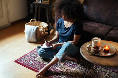 Woman sitting on the ground writing