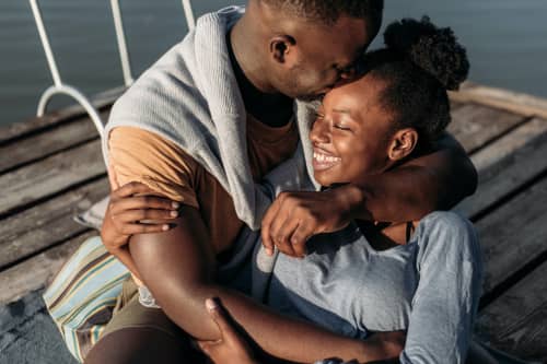 couple sitting on dock hugging