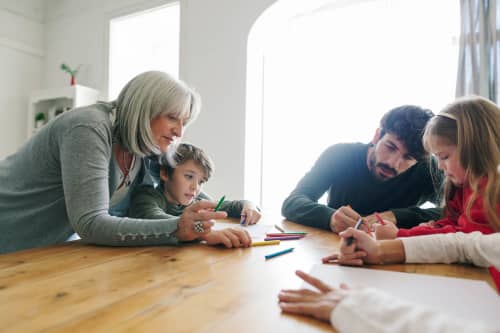 Kids Painting With Their Father And Grandmother At Home.