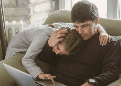 dad holding daughters head reading