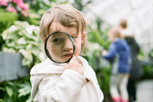 Child looking at magnifying glass