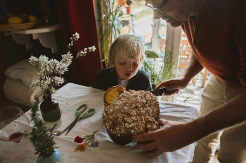 father cutting bread with son