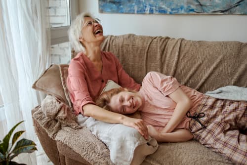 grandmother and grandchild laughing on couch