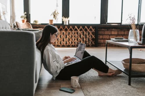 woman working on laptop on floor