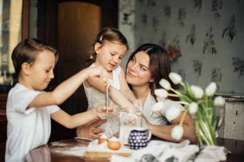 mother looking at toddlers at dining room table