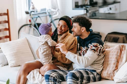 parents sitting on couch with baby