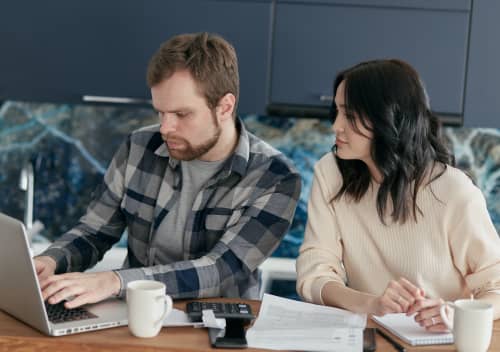 couple researching on laptop in kitchen