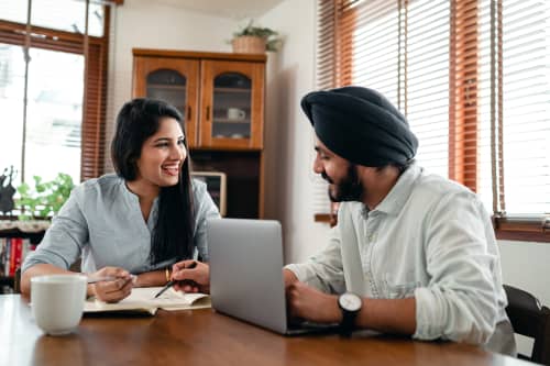 couple sitting at table on laptop