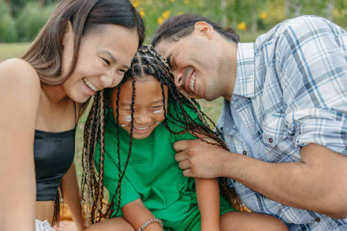 young parents laughing with daughter