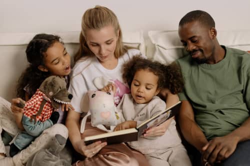 family reading book together on couch