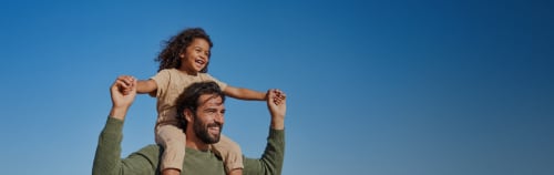 Parent carrying child in blue sky