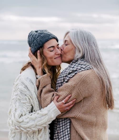 Mother kissing daugher on cheek