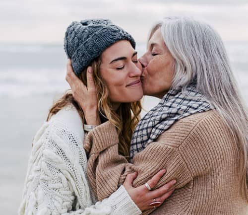 mother kissing daughter's cheek