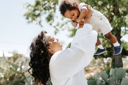 mother lifting toddler into the air