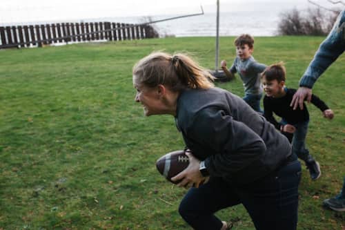 mother playing football with family