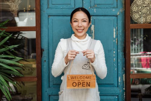 woman holding open sign