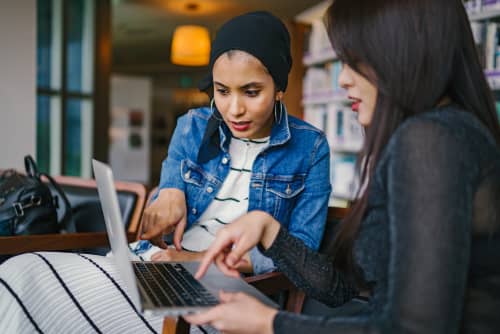 women working together on laptop