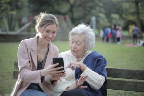 mother helping elderly mother on cellphone