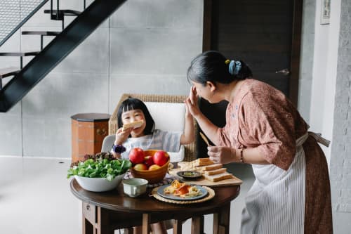 Grandmother and granddaughter eating dinner