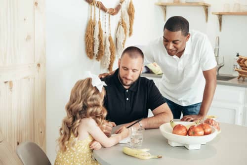 dads helping daughter with schoolwork at dining table