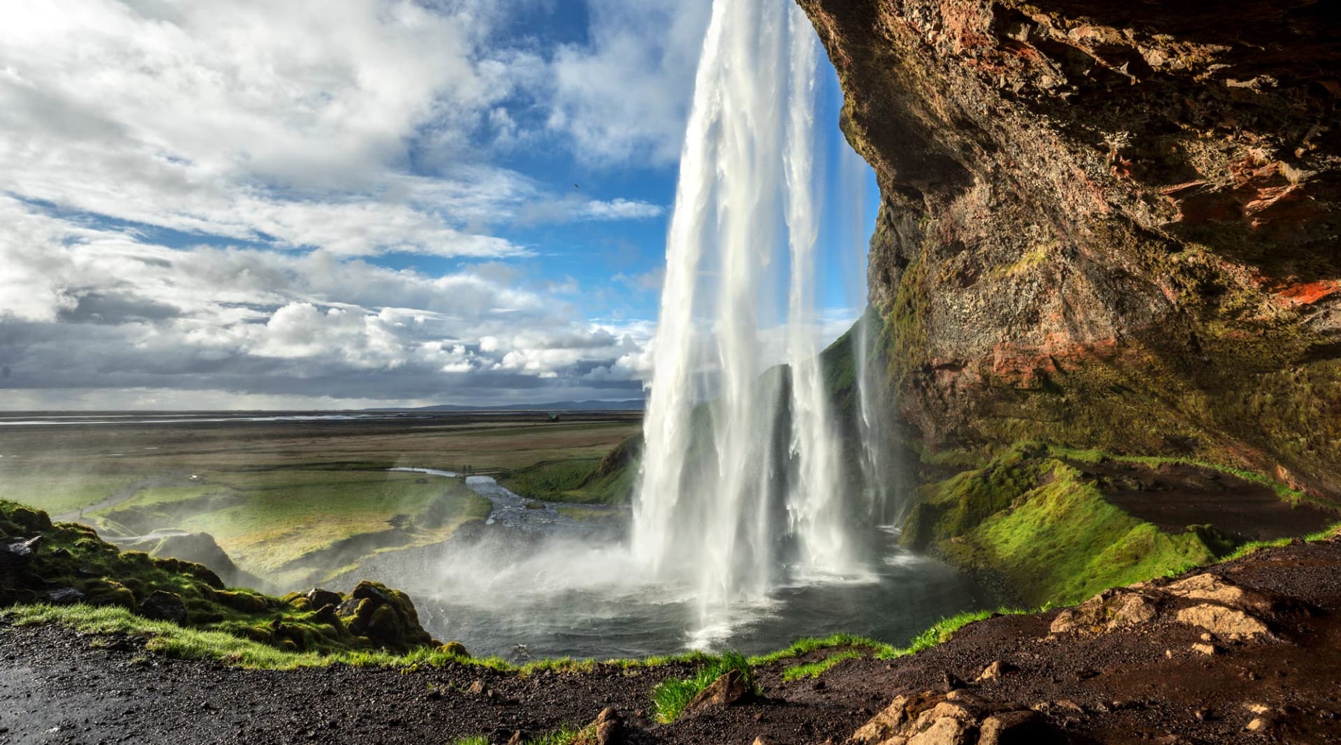 A waterfall plunges from cliffs