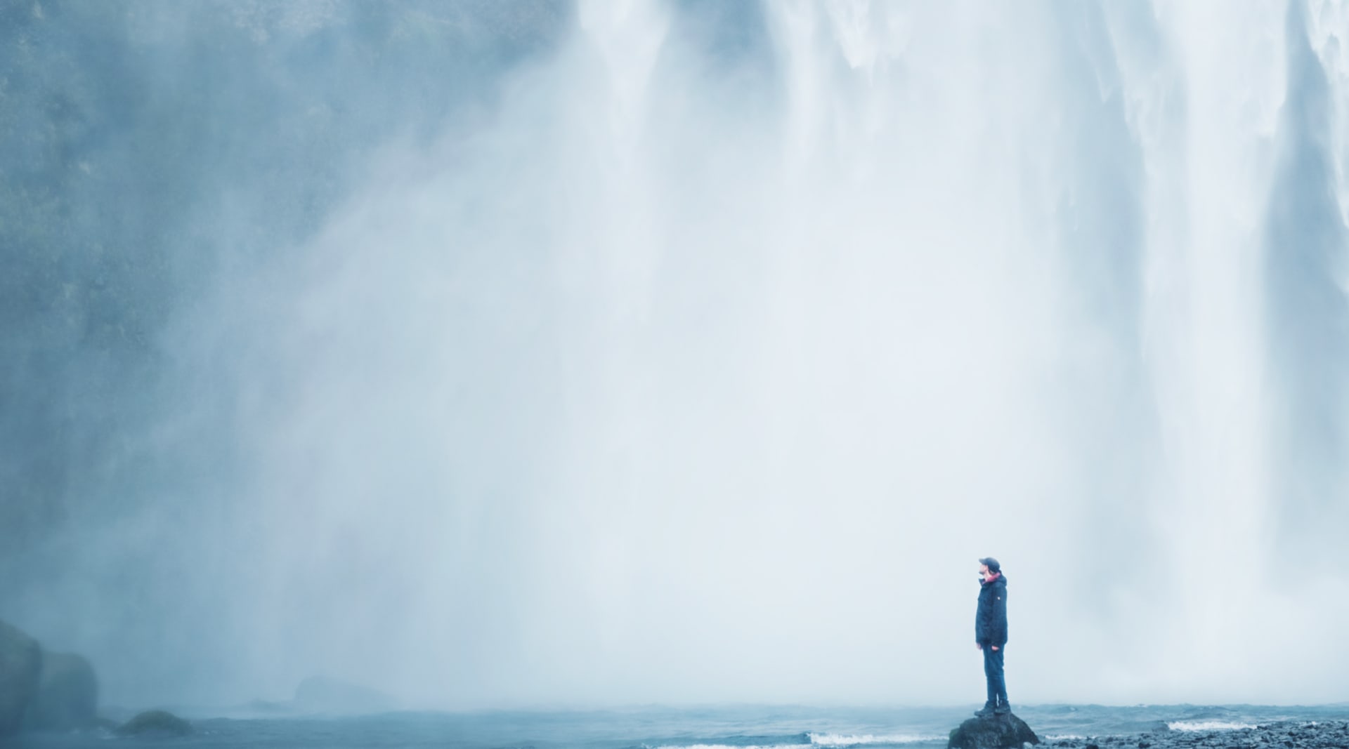 Feeling the power from dropping waters of Skógarfoss waterfall Iceland