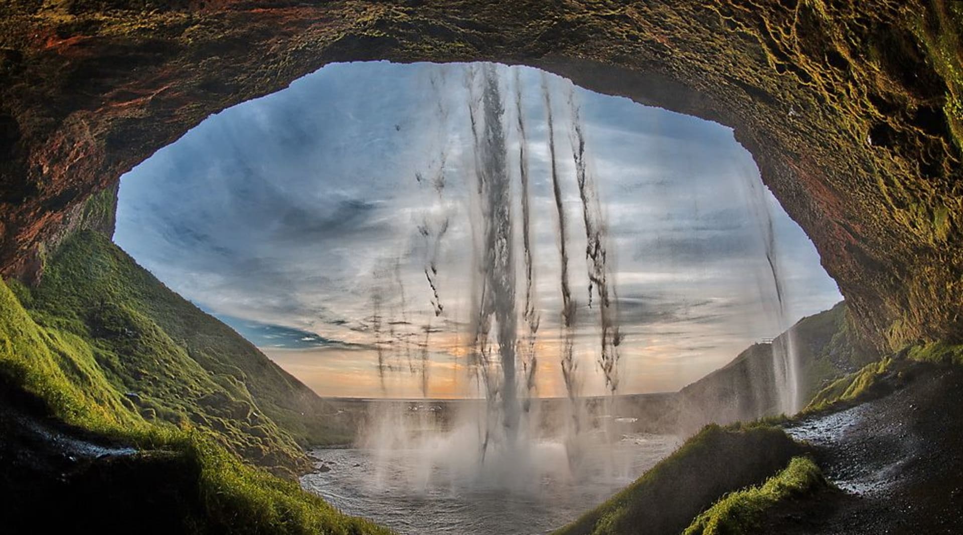 Walk behind Seljalandsfoss waterfall and feel the power of the elements