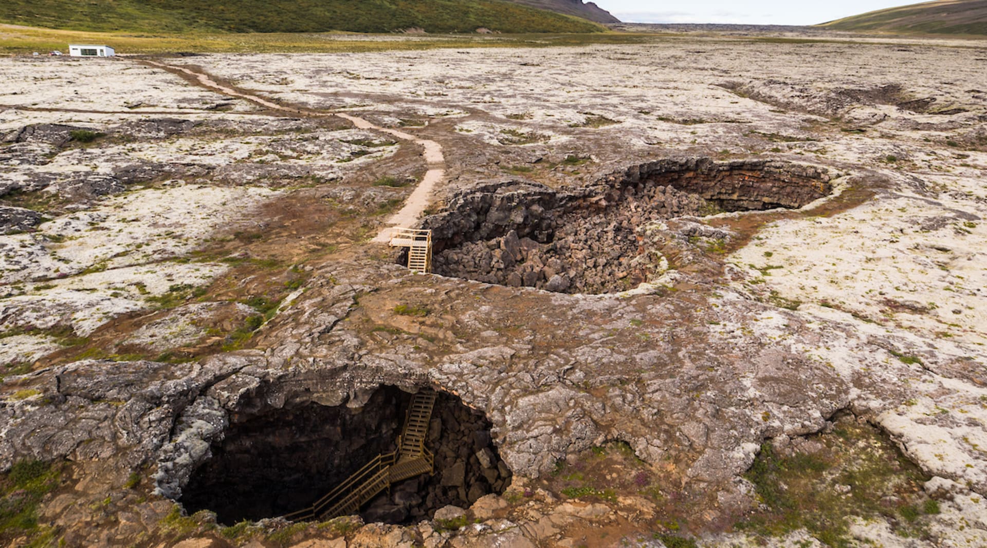 An elevated view of the caves only entrances. The accessible main entrance is visible behind the smaller "skylight".