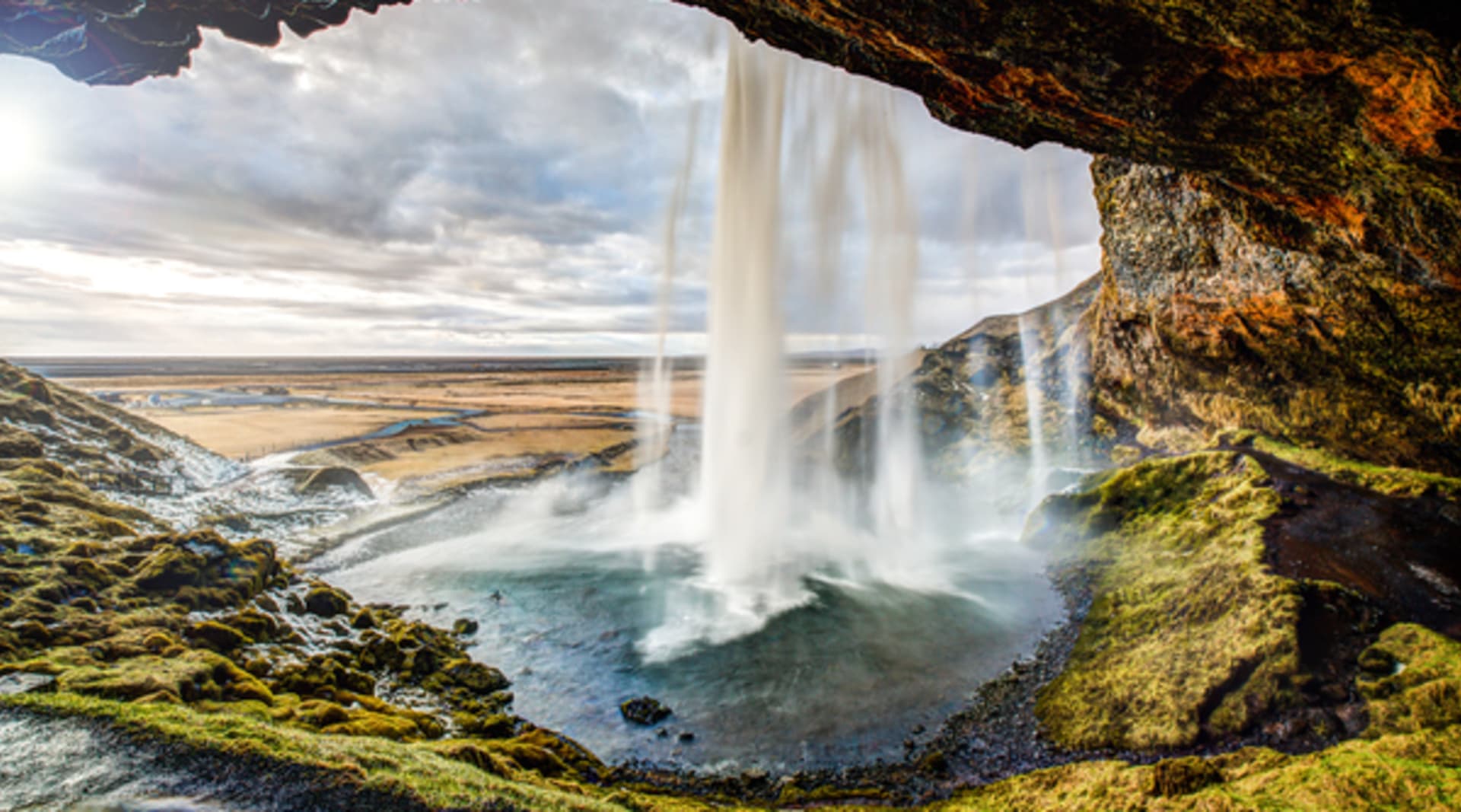 Taking the secret path behind the waterfall of Seljalandsfoss waterfall