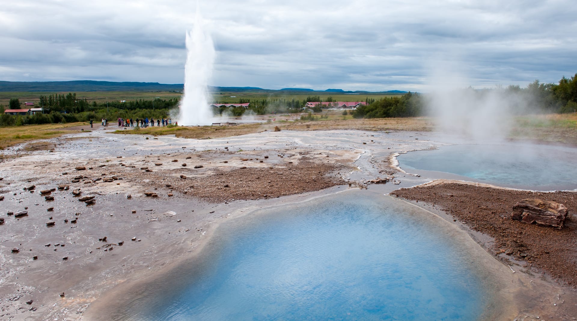 Blue hot spring with Geysir in distance