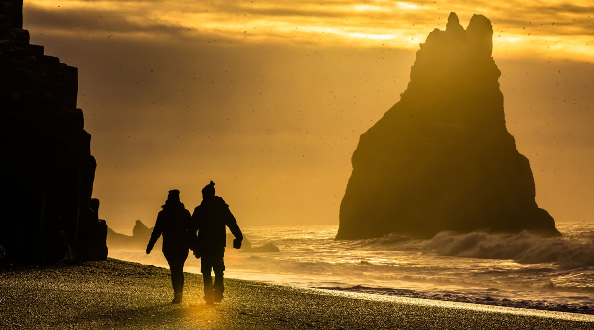 Black Sand Beach with people holding hands and walking