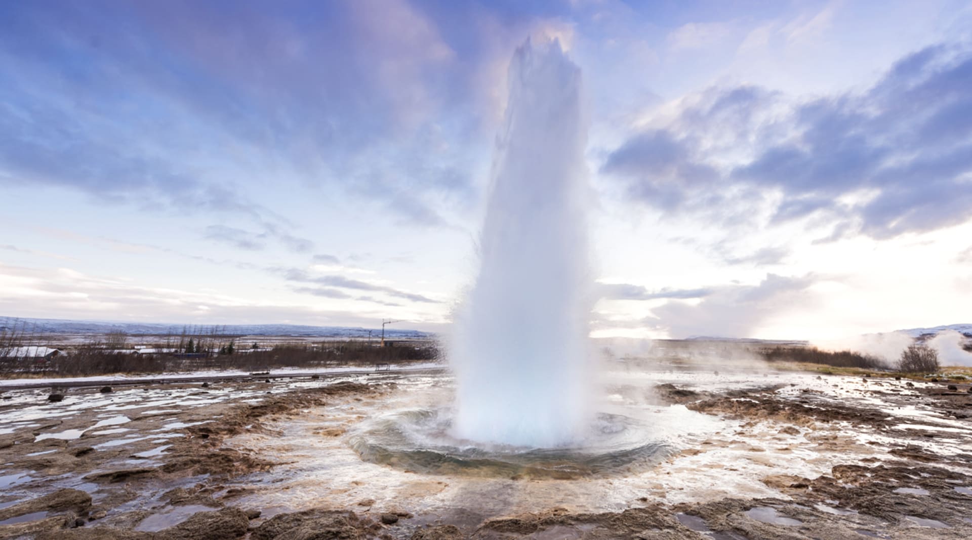 Strokkur winter with blue sky sunrise