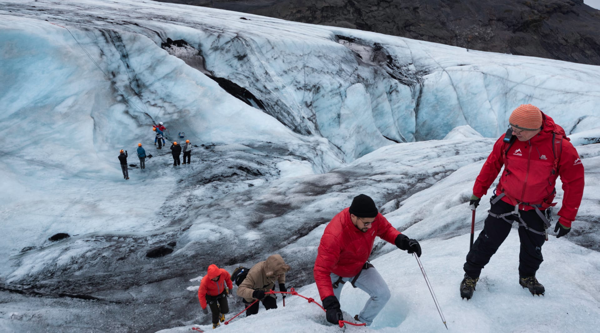 Group of people hiking and climbing on a glacier