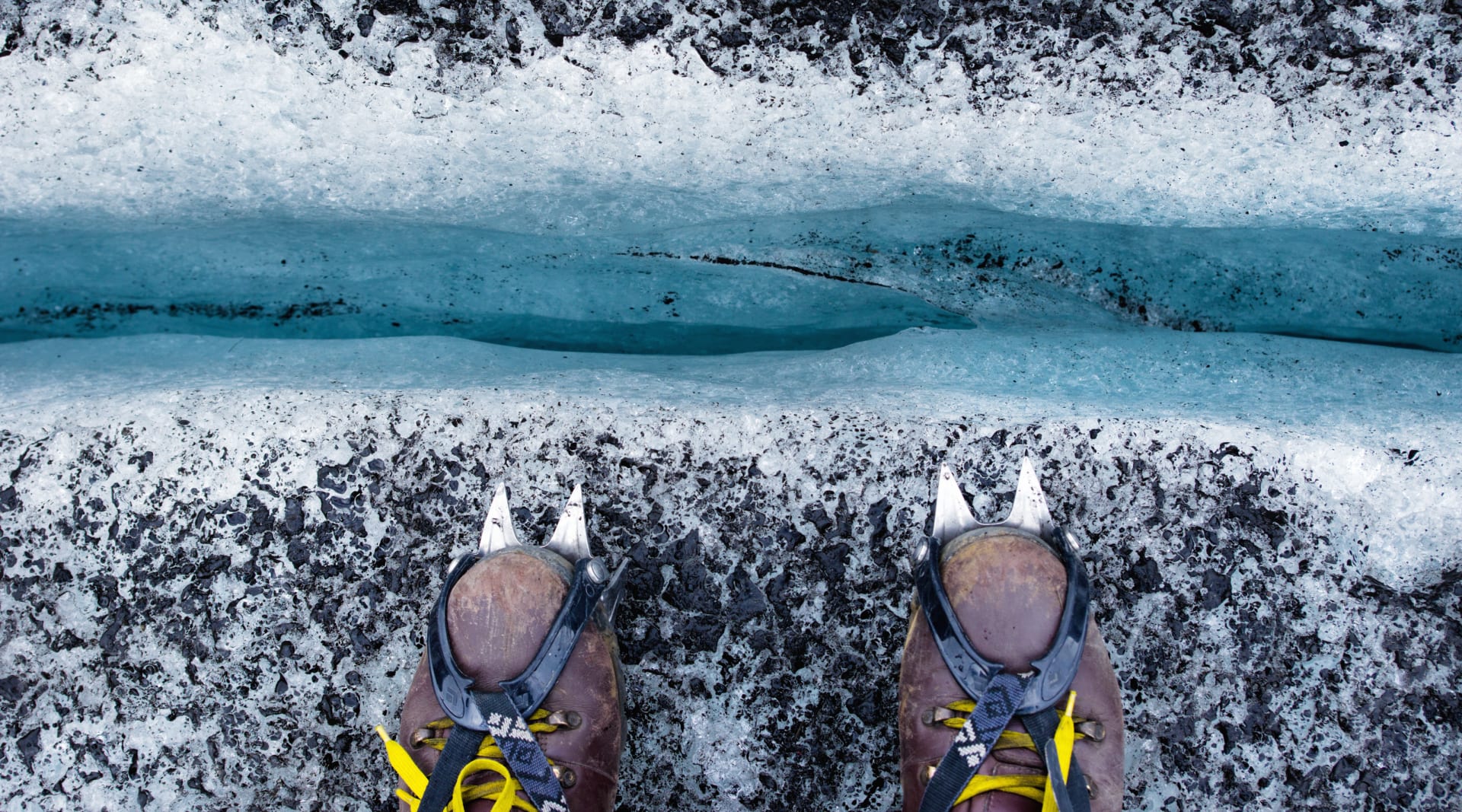 Glacier hiking, hiking shoes with crampons, looking down a crevasse, blue ice