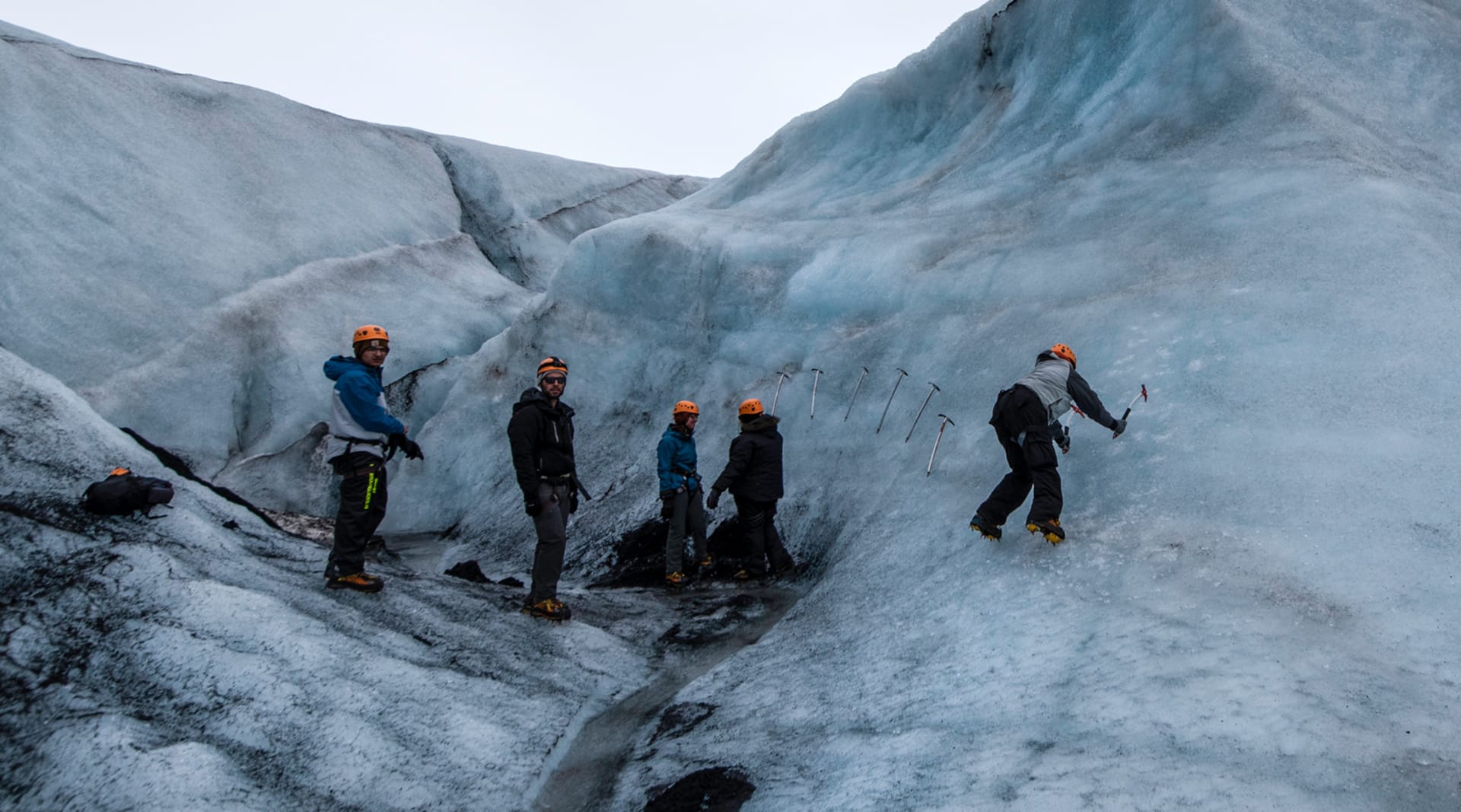 People hiking and climbing on a glacier