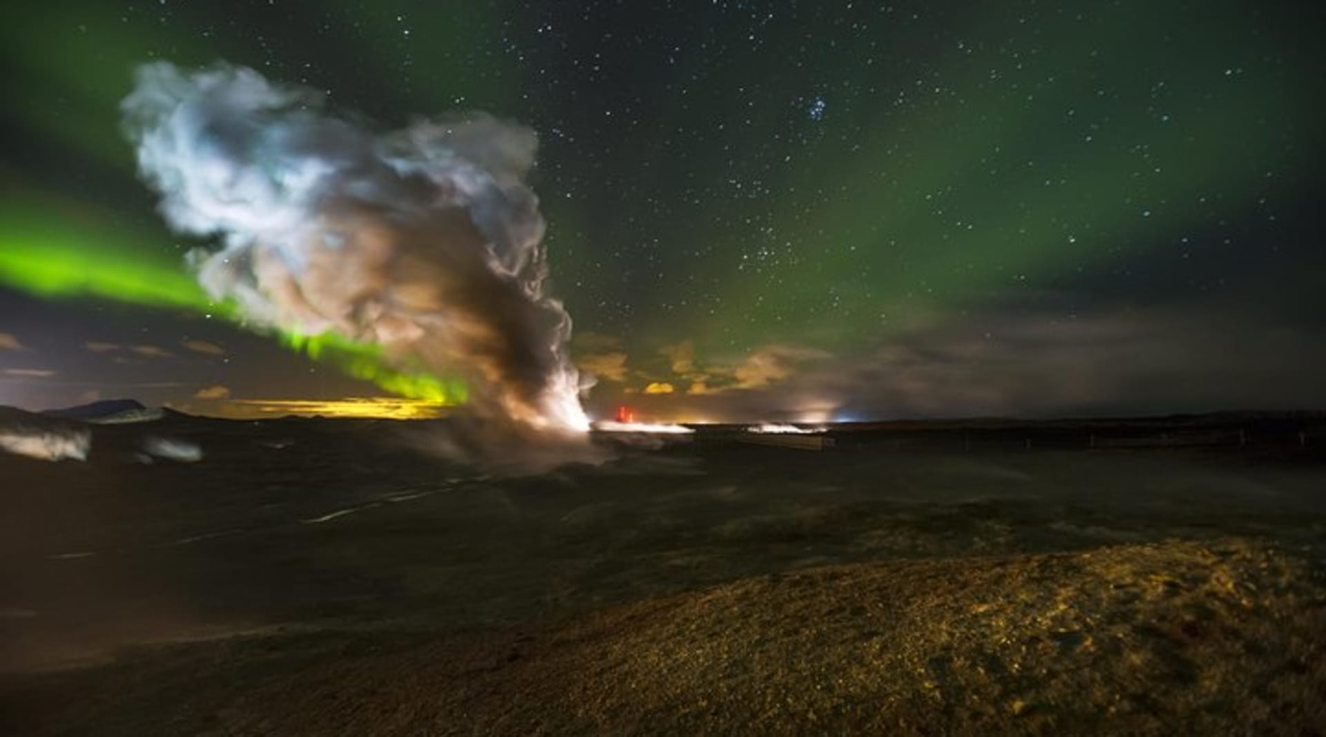 Northern Lights behind a column of steam coming from one of Iceland's largest geothermal areas.