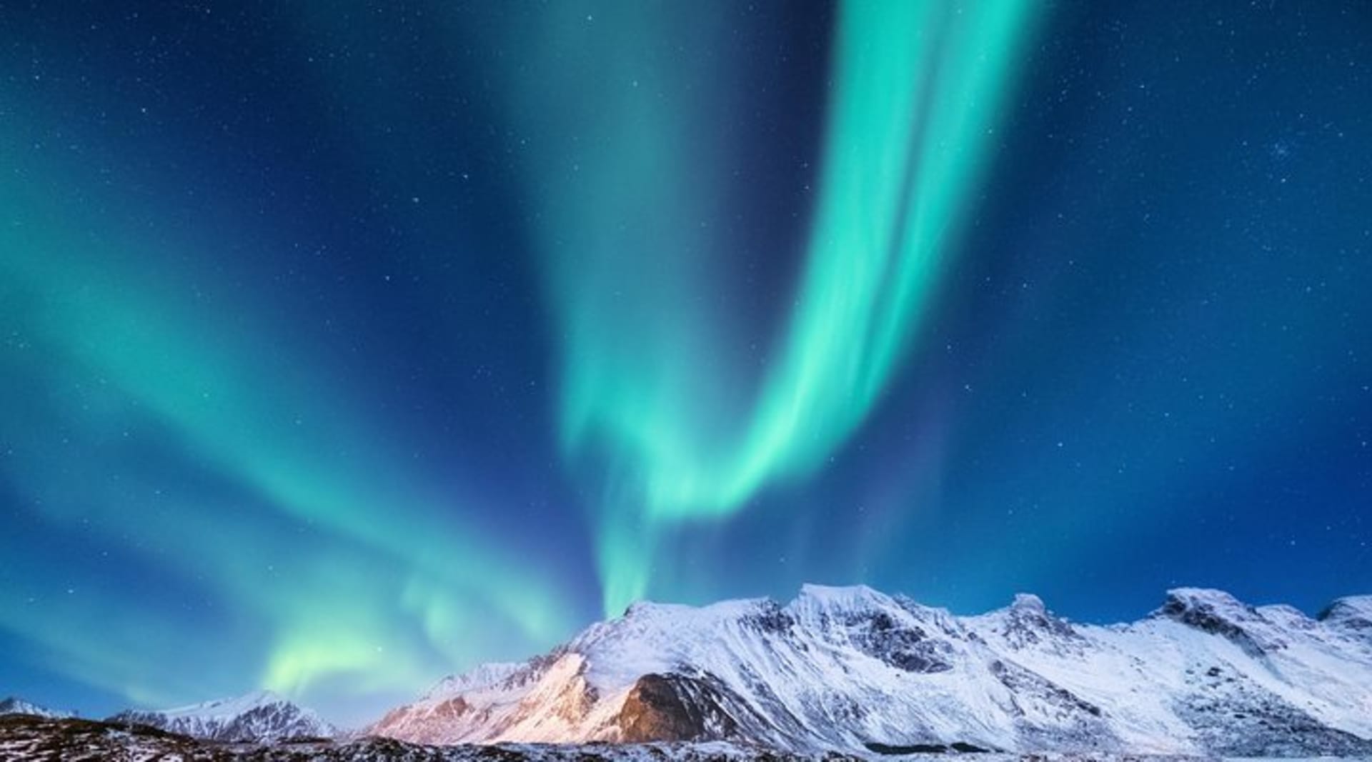 Northern Lights over a snow-covered mountain in Iceland