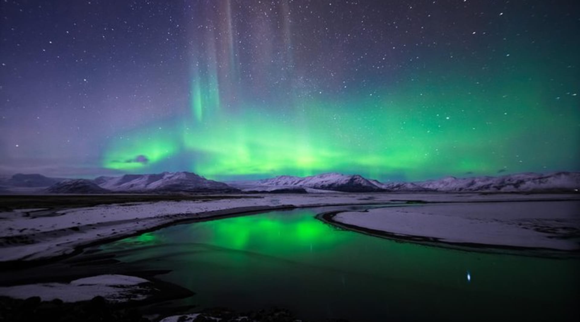 The spectacular show of the Northern Lights over a snow-covered Icelandic landscape