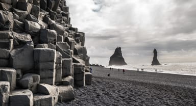 Thumbnail about Black basalt sand and basalt columns at beautiful Reynisfjara beach