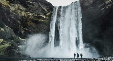 Thumbnail about Skogafoss waterfall with people standing next to falls