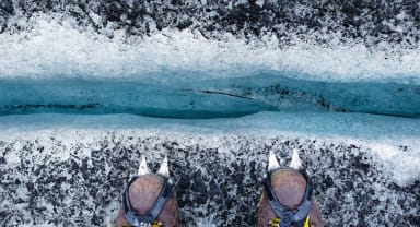 Thumbnail about Glacier hiking, hiking shoes with crampons, looking down a crevasse, blue ice