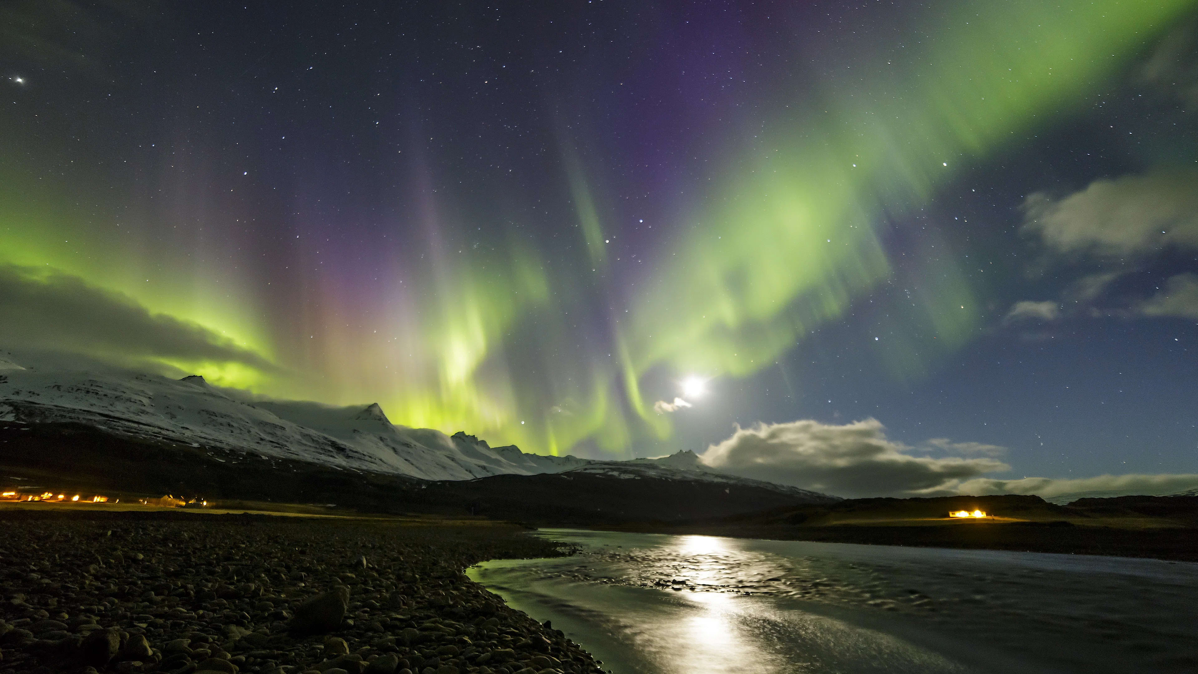 standing on the coast of Iceland, overlooking the North Atlantic Ocean with visible northern lights in the sky