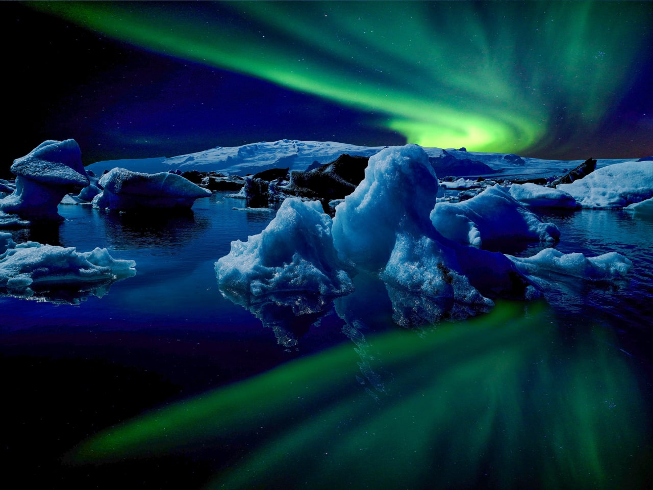 The northern lights dancing above the icebergs in the glacier lagoon Jökulsárlón