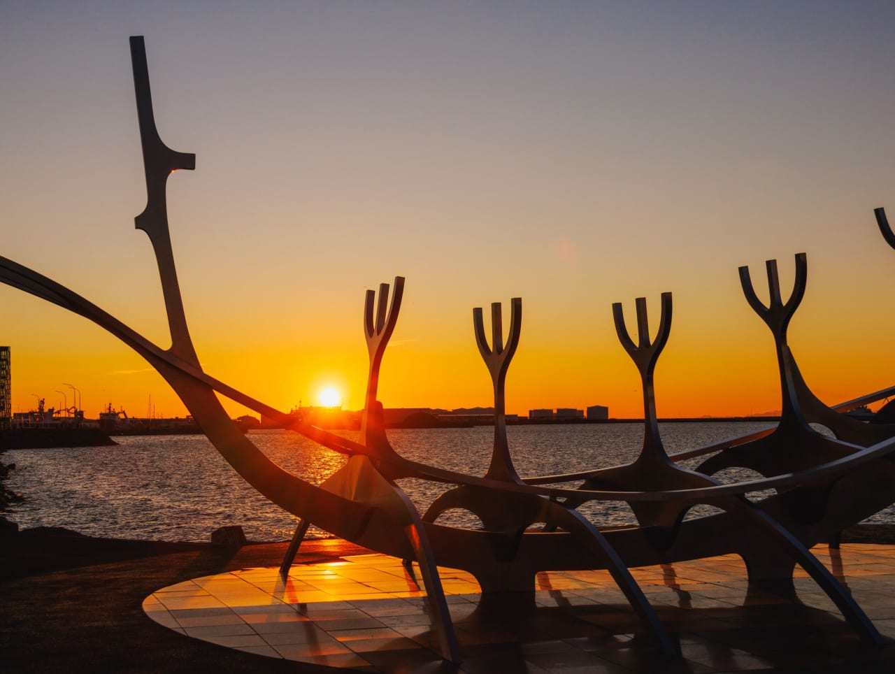 The midnight sun setting behind the Sun Voyager sculpture in downtown Reykjavík