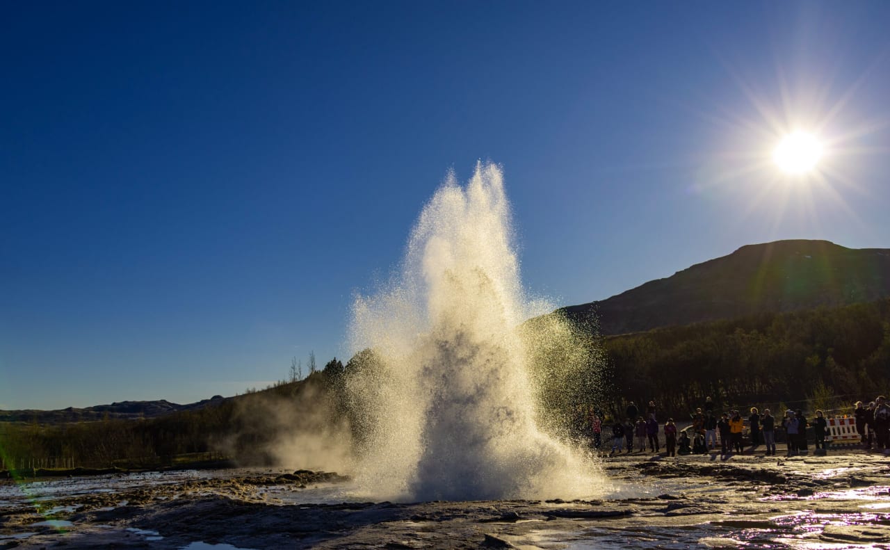 An erupting geyser late at night during summer in Iceland
