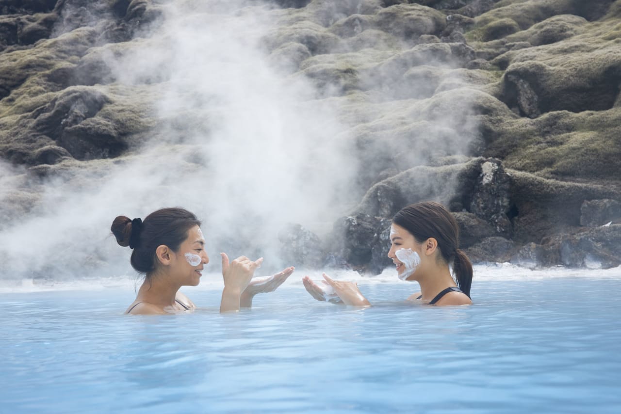 A mother and daughter putting on a white silica mask at the Blue Lagoon in Iceland