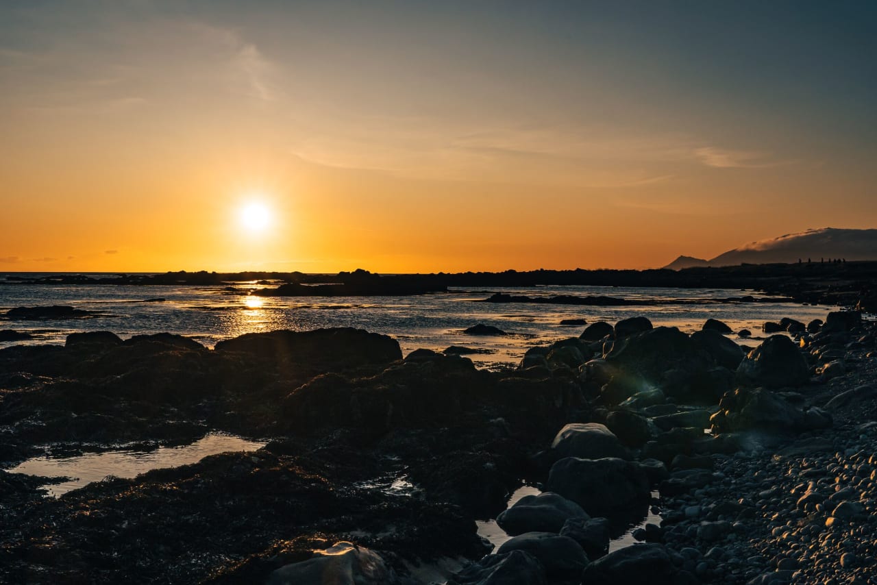 The sun setting at the beach on a summer day