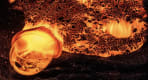 Thumbnail about Close-up of a glowing molten lava formation bubbling on a black sandy surface, captured in vivid orange and red tones.