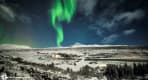 Thumbnail about Green Northern lights strip over snowy Thingvellir national park in Iceland