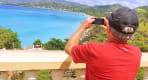 Thumbnail about A Traveler taking photos of the famous grand anse beach.
